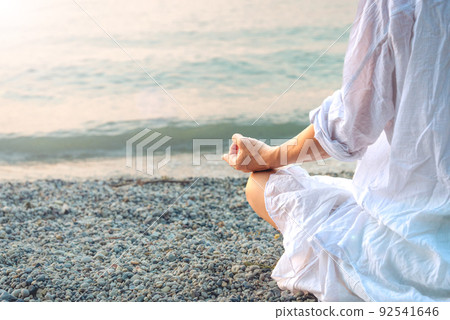 Woman meditating at the Garda Lake. Sunset. Woman meditating at the Garda Lake. Sunset. 92541646