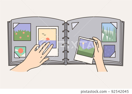 Person put picture in photo album  92542045