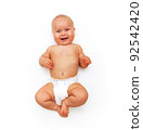 A tanned Caucasian baby in a white diaper laughs. Isolated on a white background 92542420