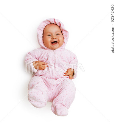 a pretty laughing girl in a pink jumpsuit is lying on her back and kicking her legs. View from above. Isolated on white 92542426