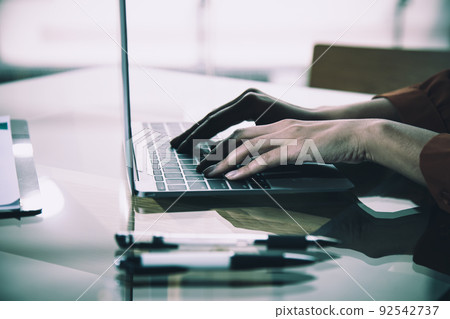 Yonug adult woman sitting in cafe and close up hand typing using laptop 92542737