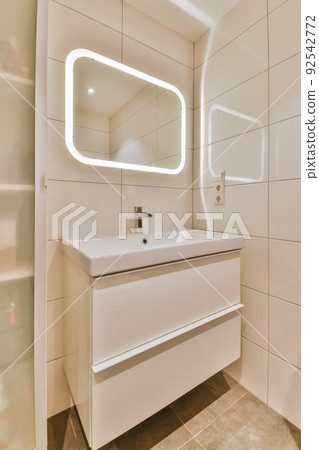 Sink with tap and liquid soap hanging on tiled wall under mirror in contemporary restroom at home Sink with tap and liquid soap hanging on tiled wall under mirror in contemporary restroom at home 92542772