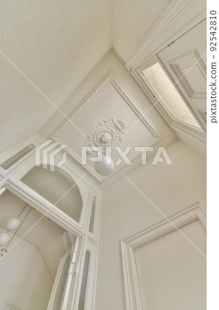 From below classic plaster floral ornament of medallion decorating ceiling above elegant chandelier at home 92542810