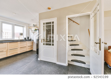 White staircase in the kitchen connecting the floors of a modern apartment 92543199