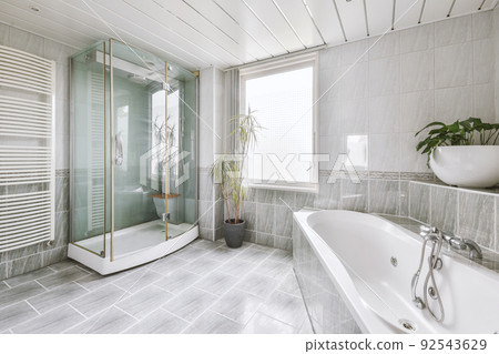 Luxurious bathroom interior design with marble walls, glass shower, corner bathtub, clothes dryer, plants and window Luxurious bathroom interior design with marble walls, glass shower, corner bathtub, clothes dryer, plants and window 92543629