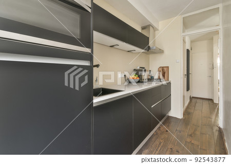 Design of mansard kitchen with wooden cabinets and minimalist interior under roof beams Design of mansard kitchen with wooden cabinets and minimalist interior under roof beams 92543877