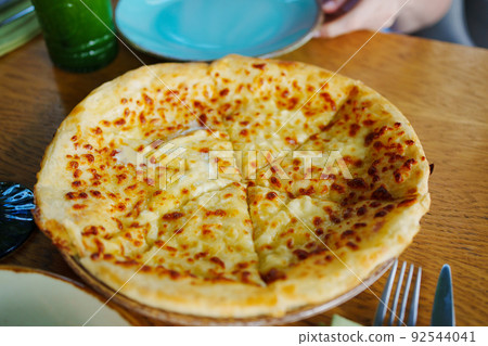 cut into pieces of imeretian khachapuri. cut into pieces of imeretian khachapuri. 92544041