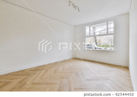Interior of empty white room with large windows with curtains and wooden parquet floor 92544450