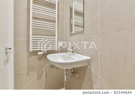 Sink with tap and liquid soap hanging on tiled wall under mirror in contemporary restroom at home Sink with tap and liquid soap hanging on tiled wall under mirror in contemporary restroom at home 92544684