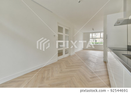 Interior of empty white kitchen with windows and wooden parquet floor Interior of empty white kitchen with windows and wooden parquet floor 92544691