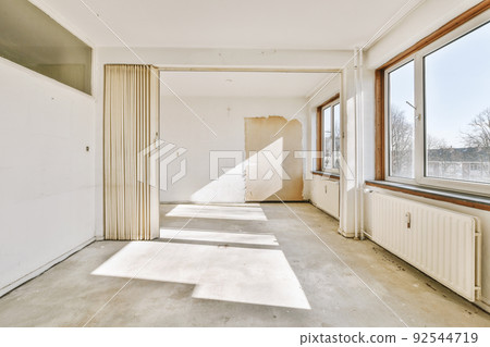 Plastic window and radiator on white wall in empty light room at home Plastic window and radiator on white wall in empty light room at home 92544719