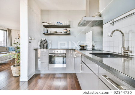 Corner cupboards and table with chairs located in light kitchen of contemporary flat Corner cupboards and table with chairs located in light kitchen of contemporary flat 92544720