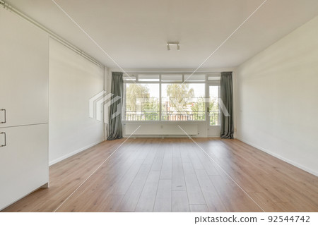 Interior of empty white kitchen with windows and wooden parquet floor 92544742
