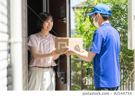 Female delivery person who receives the parcel Female delivery person who receives the parcel 92544754