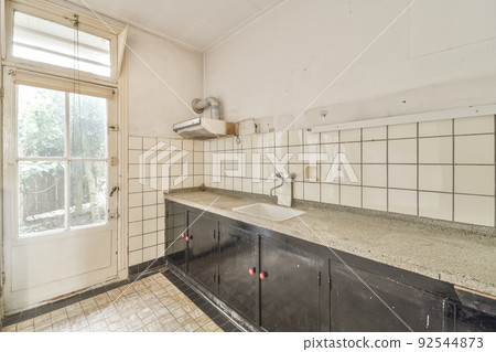 Design of mansard kitchen with wooden cabinets and minimalist interior under roof beams Design of mansard kitchen with wooden cabinets and minimalist interior under roof beams 92544873