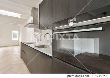 Interior of empty white kitchen with windows and wooden parquet floor Interior of empty white kitchen with windows and wooden parquet floor 92544945