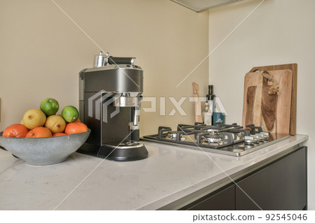 Design of mansard kitchen with wooden cabinets and minimalist interior under roof beams 92545046