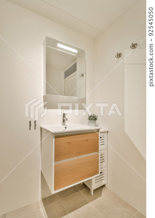 Sink with tap and liquid soap hanging on tiled wall under mirror in contemporary restroom at home Sink with tap and liquid soap hanging on tiled wall under mirror in contemporary restroom at home 92545050