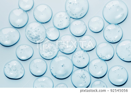 Liquid gel abstract cosmetic swatch drops on blue background. Smear of transparent moisturizing product Liquid gel abstract cosmetic swatch drops on blue background. Smear of transparent moisturizing product 92545056