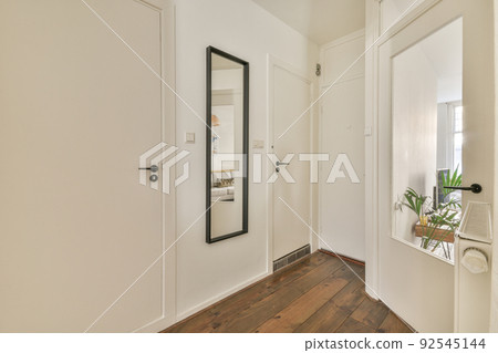 Narrow light corridor with doors of rooms illuminated with lamps inside modern hotel Narrow light corridor with doors of rooms illuminated with lamps inside modern hotel 92545144
