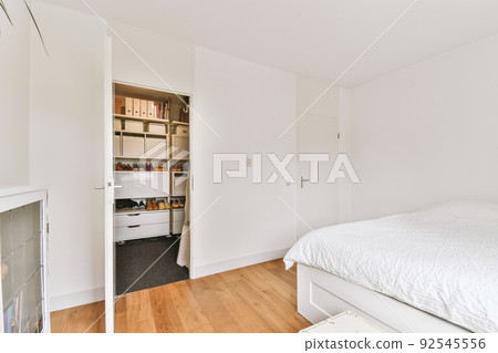 White wardrobe with mirrors located in light room at home 92545556
