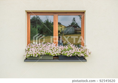 Beautiful style window decorated with light summer flowers in Poland Beautiful style window decorated with light summer flowers in Poland 92545620