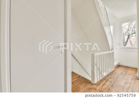 From above of narrow spiral stairway with white stairs and railing on wall inside of modern apartment From above of narrow spiral stairway with white stairs and railing on wall inside of modern apartment 92545759