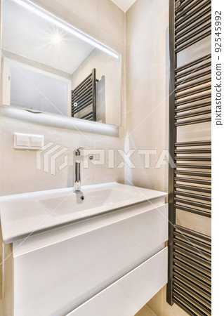Sink with tap and liquid soap hanging on tiled wall under mirror in contemporary restroom at home Sink with tap and liquid soap hanging on tiled wall under mirror in contemporary restroom at home 92545992