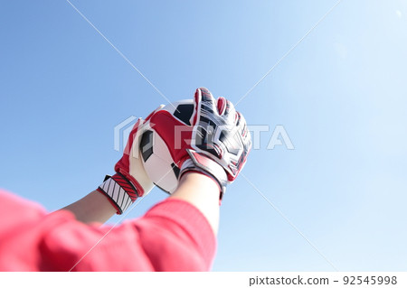 Goalkeeper man catching a soccer ball 92545998