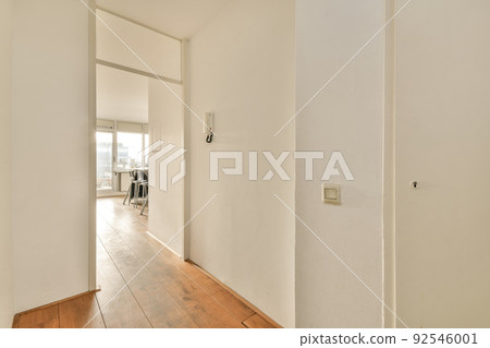 Light narrow hallway with many doors in white walls and glowing lamp over lumber floor Light narrow hallway with many doors in white walls and glowing lamp over lumber floor 92546001