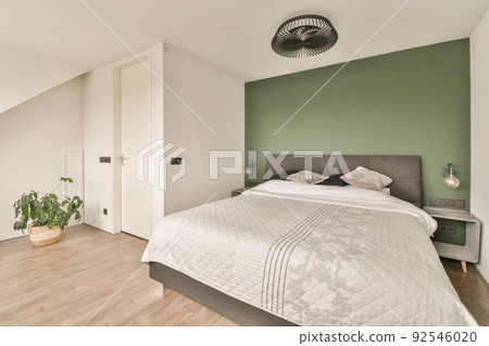 Home interior design of bedroom with bed and wooden wardrobe placed in corner near window in modern apartment Home interior design of bedroom with bed and wooden wardrobe placed in corner near window in modern apartment 92546020