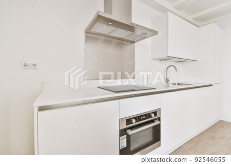 Interior of empty white kitchen with windows and wooden parquet floor Interior of empty white kitchen with windows and wooden parquet floor 92546055