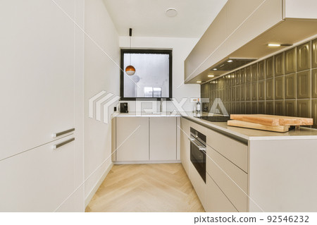Corner cupboards and table with chairs located in light kitchen of contemporary flat 92546232