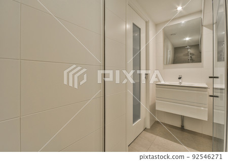 Sink with tap and liquid soap hanging on tiled wall under mirror in contemporary restroom at home Sink with tap and liquid soap hanging on tiled wall under mirror in contemporary restroom at home 92546271