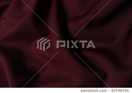 Red crumpled or wavy fabric texture background. Abstract linen cloth soft waves. Silk atlas or stretch jacquard. Smooth elegant luxury cloth texture. Concept for banner or advertisement. 92546584