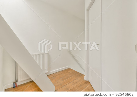 From above of narrow spiral stairway with white stairs and railing on wall inside of modern apartment From above of narrow spiral stairway with white stairs and railing on wall inside of modern apartment 92546602