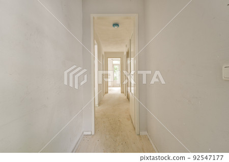 Interior of modern flat in minimal style with narrow empty corridor illuminated by lamps 92547177
