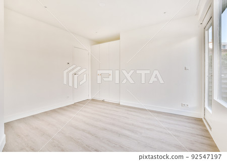 Empty room interior with white walls, cabinets, door and parquet floor 92547197
