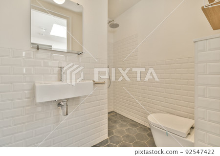 Modern home interior design of white bathroom with open bathtub and shower separated from toilet by partition wall 92547422
