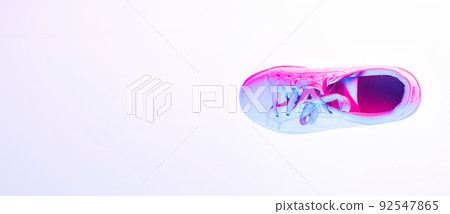 One sports shoe isolated over neoned background. Urban city fashion, fitness, sport, training concept. 92547865