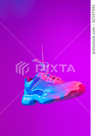 Modern sports shoes over neoned background. Sneakers or trainers isolated. Athletic shoes. fitness, sport, training concept. Urban fashion 92547895
