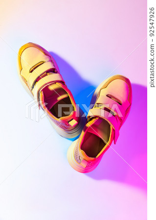 Aerial view of sports shoes, sneakers isolated over neoned background. Urban city fashion, fitness, sport, training concept. 92547926