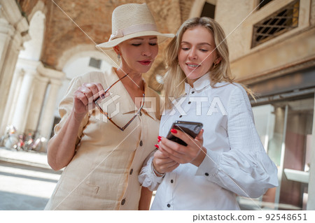 Two women looking at the smartphone screen Two women looking at the smartphone screen 92548651