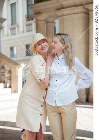 Pleased lady posing for the camera with her daughter Pleased lady posing for the camera with her daughter 92548656