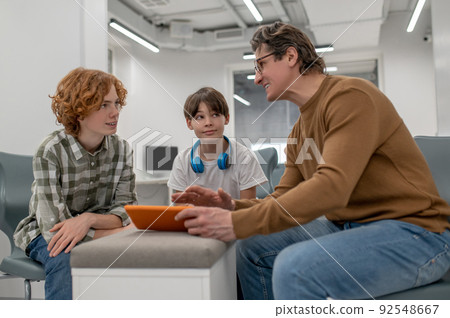 Teacher in eyeglasses explaining something to his students 92548667