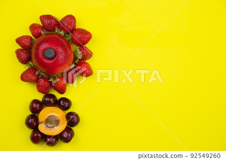 Creative flowers consisting of apricot and cherry and apple and strawberry lie on the side on a yellow background with space for text. High quality photo Creative flowers consisting of apricot and cherry and apple and strawberry lie on the side on a yellow background with space for text. High quality photo 92549260