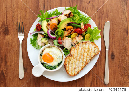 One plate of chicken salad, bread, eggs and spinach cocotte 92549376