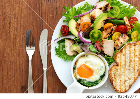 One plate of chicken salad, bread, eggs and spinach cocotte One plate of chicken salad, bread, eggs and spinach cocotte 92549377