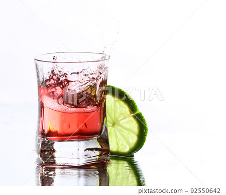 red cocktail with lime on white 92550642