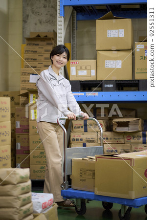 Business scene: A woman working in a warehouse Business scene: A woman working in a warehouse 92551311